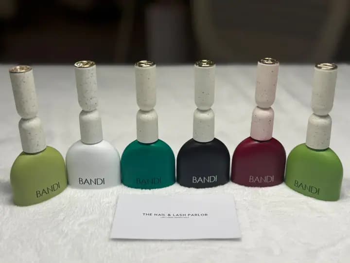 Six BANDI polish bottles beside a card printed for the parlor.