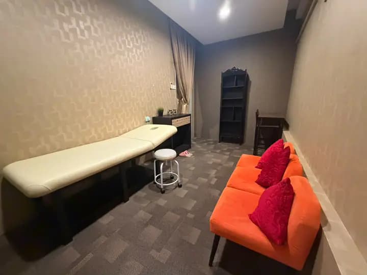 The private room from the other end, with the treatment bed on the left and the orange chairs on the right.