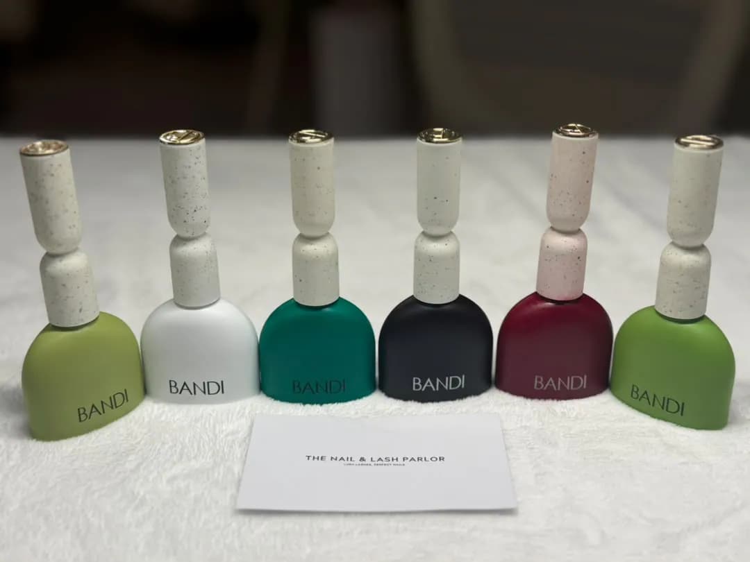 Six BANDI polish bottles beside a card printed for the parlor.