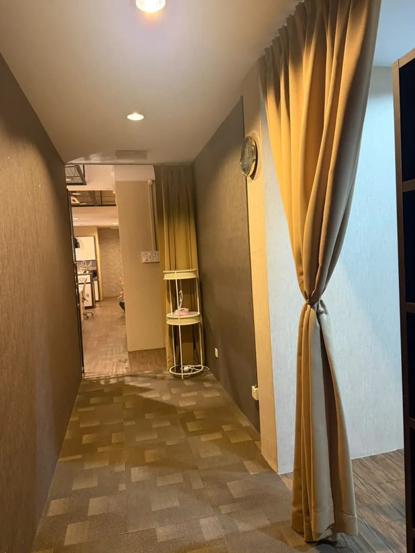 Hallway with a tied beige curtain, carpet, and a shelf.
